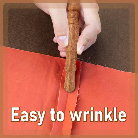 Go-To Stiletto and Pressing Tool for Quilting and Sewing used on brown fabric, close up of hand holding the wooden handle