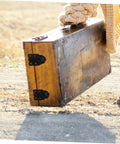 Retro Style Duckbilled Toggle Hasp Lock for wooden tool box with black metal latch on dusty path.