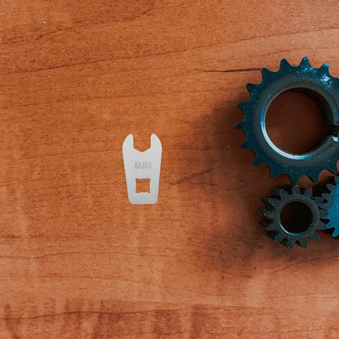 Slick Steel Hand Torque Wrench With Eight Millimeter Open End Jaw Portable Bike Gear on wooden surface next to gears.