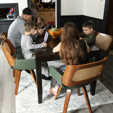 Family seated at a dining table with Set Of 2 Swivel Dining Chairs With Curved Arms, Ergonomic Cane Back, Bentwood Frame, in Walnut Beige.
