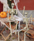 Two-Pack 36 Inch Pose N Stay Skeleton Decorations in outdoor Halloween setup with cobwebs and pumpkin
