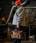 Worker holding Onsite Tool Bag for Worksite, Heavyweight 16-Inch Tote with 30 Pockets, Internal Frame and 1200 Denier Fabric, Black.