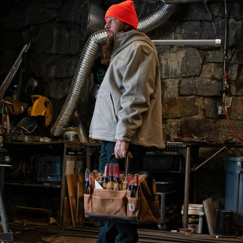 Worker holding Onsite Tool Bag for Worksite, Heavyweight 16-Inch Tote with 30 Pockets, Internal Frame and 1200 Denier Fabric, Black.