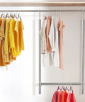Adjustable Hanging Closet Rod Chrome Finish Extends From 18.75 To 30.5 Inches In 7 Positions, displaying clothes in closet setup.