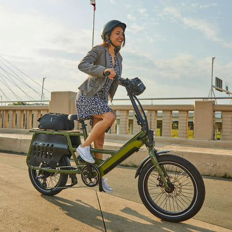 Person riding green e-bike with Two Pack Beefy 20x3 E-Bike Inner Tubes For Fat Tires 64/76-406 AV32mm Schrader Valve on city bridge.