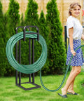 Heavy Duty Freestanding Garden Hose Holder With Upgraded 150 Ft Capacity Metal Hose Stand in yard with woman using hose
