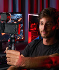 Man using PIXI Mini Tripod With Handgrip For Compact System Cameras, DSLRs And Mirrorless, Video Grip Stabilizer at a desk setup