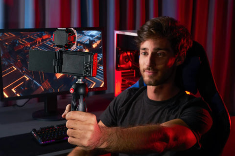 Man using PIXI Mini Tripod With Handgrip For Compact System Cameras, DSLRs And Mirrorless, Video Grip Stabilizer at a desk setup