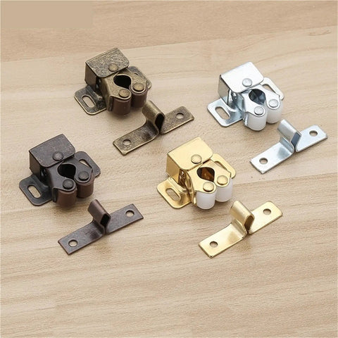 Assorted magnetic cabinet catches and door stops pack with slick closers and damper buffers in different finishes on a wooden surface.