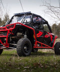 Beefed Up Billet Aluminum Rear Radius Arms For Polaris RZR XP 1000 And XP 4 1000 Models, 1-1/4 Inch 7075 Solid Aluminum Bar Upgrade Over OEM 3/4 Inch, Heavy Duty Strength, Precise Fit, Not Compatible With Polaris Rear Bumpers. Red Polaris RZR XP 1000 rear radius arms on off-road UTV