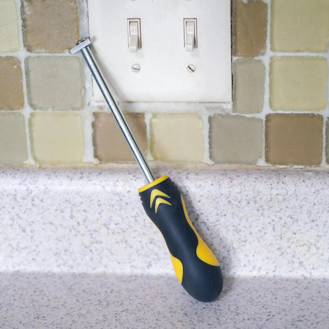 Carbide Tip Grout Removal Hand Tool With Soft Grip Reversible Triangle Blade leaning on countertop in front of tile wall.