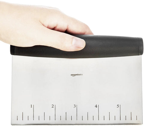 Hand holding Top Notch Pro Grade Stainless Steel Bench Scraper Dough Cutter with one quarter inch measurement marks on 6 inch blade.