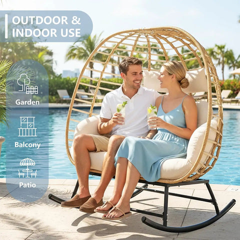 Couple seated in Double Wicker Egg Chair Rocker For Indoor Or Outdoor Patio Cozy Two Person Lounge With Thick Cushions