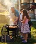 Family using Extra Large Fire Pit BBQ Grill Bowl With Mesh Spark Screen Cover, Poker And Tote Bag, Log Grate Included outdoors