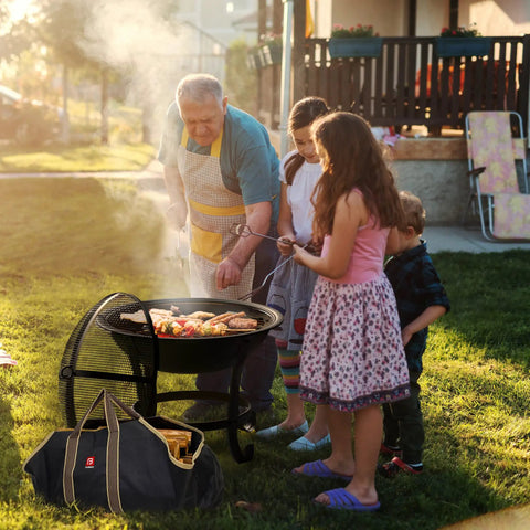Family using Extra Large Fire Pit BBQ Grill Bowl With Mesh Spark Screen Cover, Poker And Tote Bag, Log Grate Included outdoors