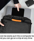 Person placing laptop in black bag with open pocket on white table, view from above