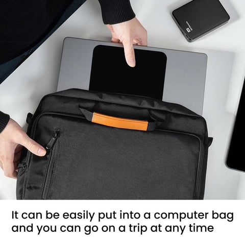 Person placing laptop in black bag with open pocket on white table, view from above