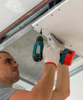 Person installing drywall with Pro Grade Heavy Duty Drywall Screws And Wood Fasteners, Black Oxide Coated Eight By Three Inch Phillips Head.