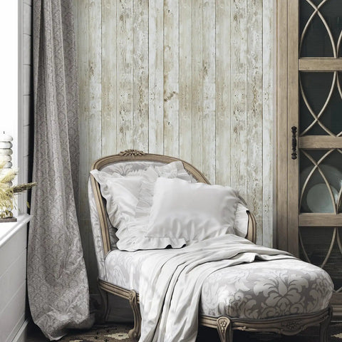 Bedroom with vintage wood shiplap peel and stick wallpaper with realistic grain texture behind an elegant chaise lounge.