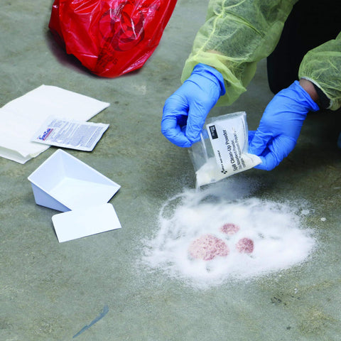 First Aid Only OSHA body fluid clean-up kit in plastic case; close-up of blue-gloved hands.