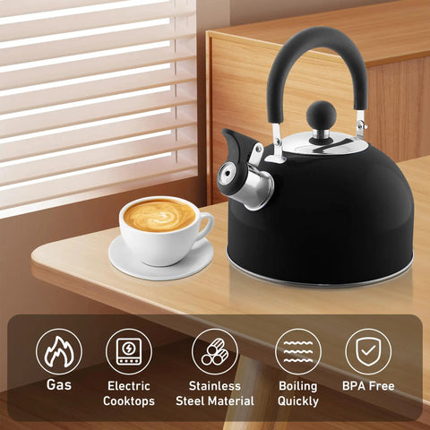 2 Quart Stainless Steel Whistling Tea Kettle For Stovetop No Fuss Quick Boil With Spill Proof Lid Works On Gas Electric Glass And Induction Ideal For Home Dorm Apartment Black on kitchen countertop next to cup of coffee.