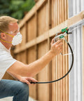 Man using Heavy Duty Mobile Airless Paint And Stain Sprayer Cart for Butter Smooth Finishes on fence panel.