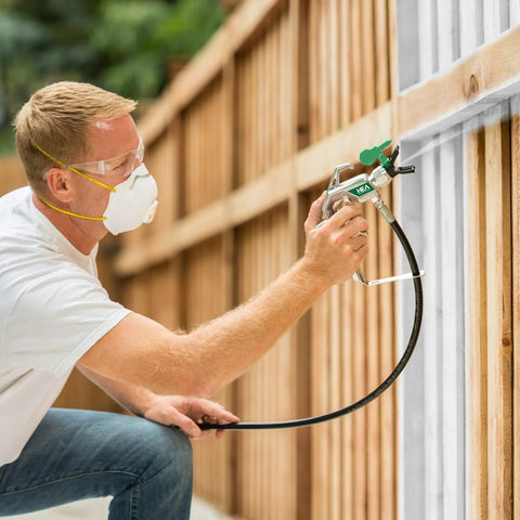 Man using Heavy Duty Mobile Airless Paint And Stain Sprayer Cart for Butter Smooth Finishes on fence panel.