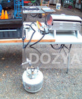 Propane Splitter Adapter With Gauge, 2 Way LP Gas Tee Connector For 20lb Tanks connected to grills on a table outdoors