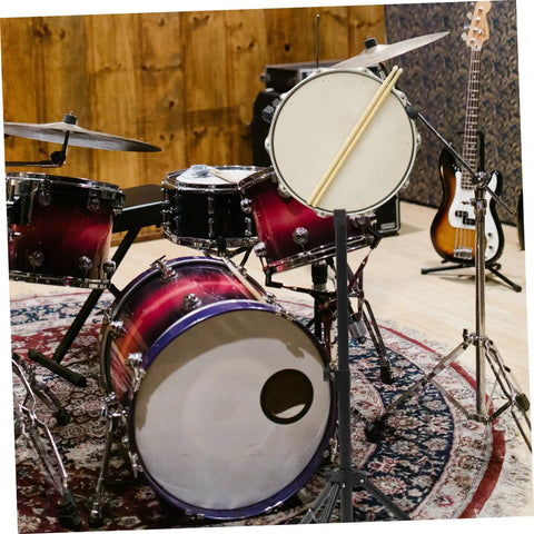 Heavy Duty Adjustable Snare Drum Rack In Matte Black With Telescopic Height Settings And Foldable Portability For Local Jam Nights Or No Sweat Travel Setup next to a vibrant drum set.