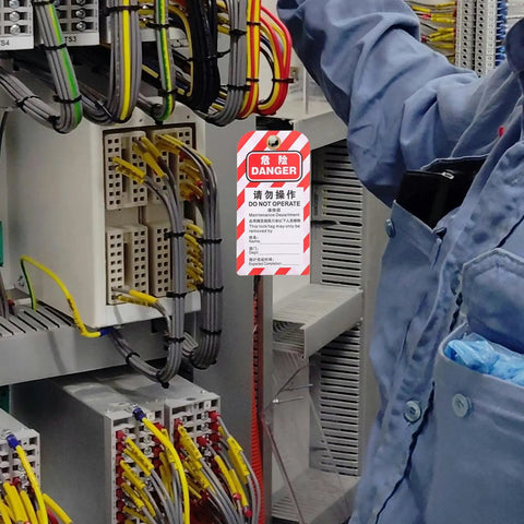 Technician applying 5 Piece Lockout Tag Kit for Equipment Repair PVC Safety Warning Tags to electrical panel