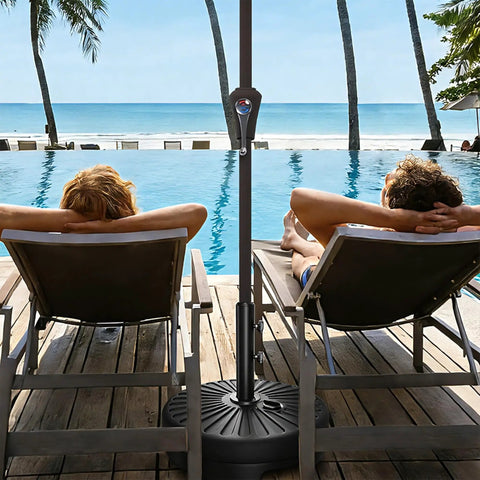 Beefed Up Heavy Duty Outdoor Umbrella Base For Market Umbrellas, 81.5 Lb Capacity Water Filled Base by poolside with loungers.