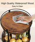 Hand wiping Rotating Spice Rack Two Tier Lazy Susan Organizer For Kitchen Countertop, brown wood surface, with spices below.