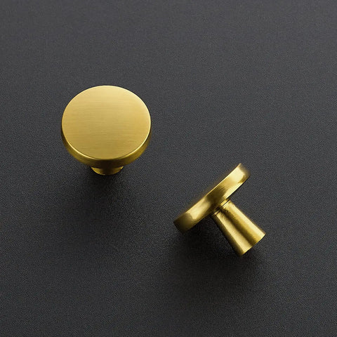 Heavy Gauge Brushed Brass Cabinet Knobs 5 Pack Featuring Smooth Round Edges And Top Shelf Solid Build To Fast Track Your Kitchen Remodel And Make Every Drawer Look Absolutely Sick. Two knobs shown from above, highlighting smooth rounded edges.
