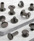 Kickass 155 Piece Black Chicago Screws And Leather Rivets Kit With Assorted M4 And M5 Sizes, carbon steel fasteners on surfaces.