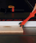 Person using Get A Grip TPR Push Stick With Reversible Notches And Bright Orange Grip For Safer Woodworking And Precise Control Twelve And Three Quarters Inch Length to guide wood on table saw
