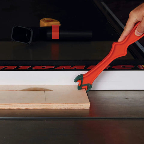 Person using Get A Grip TPR Push Stick With Reversible Notches And Bright Orange Grip For Safer Woodworking And Precise Control Twelve And Three Quarters Inch Length to guide wood on table saw