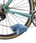 Cyclone Chain Scrubber CM-5.3 in blue attached to a multi-speed bike, showing chain cleaning process with easy grip handle.