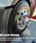 Side view of a red 33 mm lug nut cover remover socket being used on a chrome semi-truck wheel with a black tire