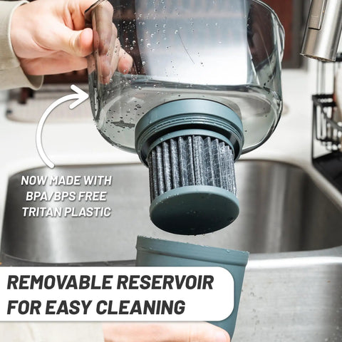 Person removing filter from No Fuss 10 Cup Gravity Water Filter Pitcher For Refrigerator With 150 Gallon Filter Easy Pour Refill Space Saving Design In Black And Bamboo Finish