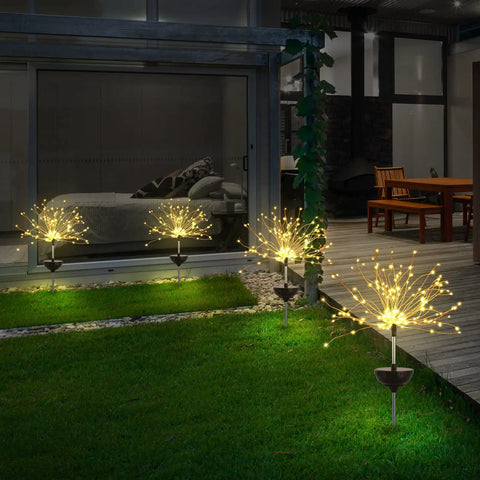 Night scene of garden with 2 Pack Solar Firework Outdoor Lights For Garden Patio Yard And Pathway Waterproof IP65 With 8 Lighting Modes in Warm White Copper Branches