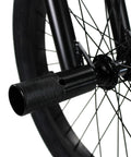 Close-up of peg on BMX Freestyle Bike with Durable Steel Frame in White for stunts; showcases black wheel and axle detail