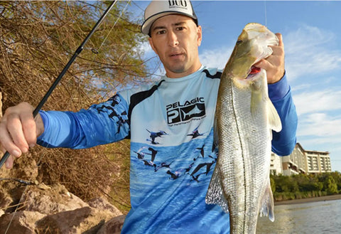 Fisherman holding a large fish caught using the 10 Piece Spinnerbait Fishing Lures Kit With Tackle Box For Freshwater And Saltwater Angling Versatile Metal Bass Trout Salmon Walleye Baits Designed For Casting Trolling And Jigging.