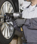 Mechanic using One Half Inch Air Impact Wrench With Five Hundred Foot Pounds Max Torque At Ninety PSI Twin Hammer Heavy Duty Pneumatic Tool With Five Speed Regulator For Lug Nuts And Tough Automotive Repairs on car tire