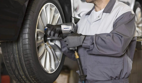 Mechanic using One Half Inch Air Impact Wrench With Five Hundred Foot Pounds Max Torque At Ninety PSI Twin Hammer Heavy Duty Pneumatic Tool With Five Speed Regulator For Lug Nuts And Tough Automotive Repairs on car tire