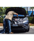 Mechanic using Heavy-Duty 24 By 34 Inch Black Plush Vinyl Fender Cover Pad for auto repair, shielding car paint under hood.