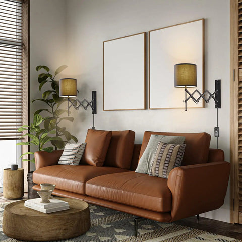 Plug In LED Wall Sconce Set Of 2 In Dark Grey illuminating a modern living room above a brown leather sofa.