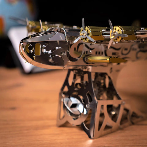 Close-up of Splashing Dreamer 3D Metal Airplane Model Kit With Wind-Up Moving Mechanism on display stand, propellers visible.