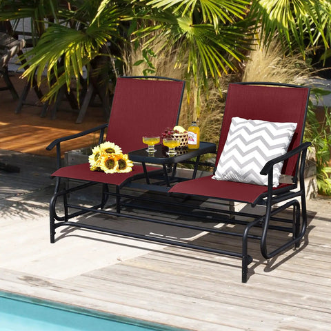 Two Person Swing Glider Chair With Center Tempered Glass Table Outdoor Patio Rocking Loveseat On Steel Frame With Breathable Mesh Fabric Perfect Balcony Or Poolside Seating In Burgundy with drinks and sunflowers.