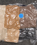 Ultimate Vacuum Seal Kit For Compression Bags with clothes sealed inside using blue valve plug on carpet