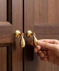 Top Shelf Heavy Duty Solid Brass Cabinet Knob Featuring Slick Brushed Gold Finish Smooth Glide Movement on wooden cabinet doors.
